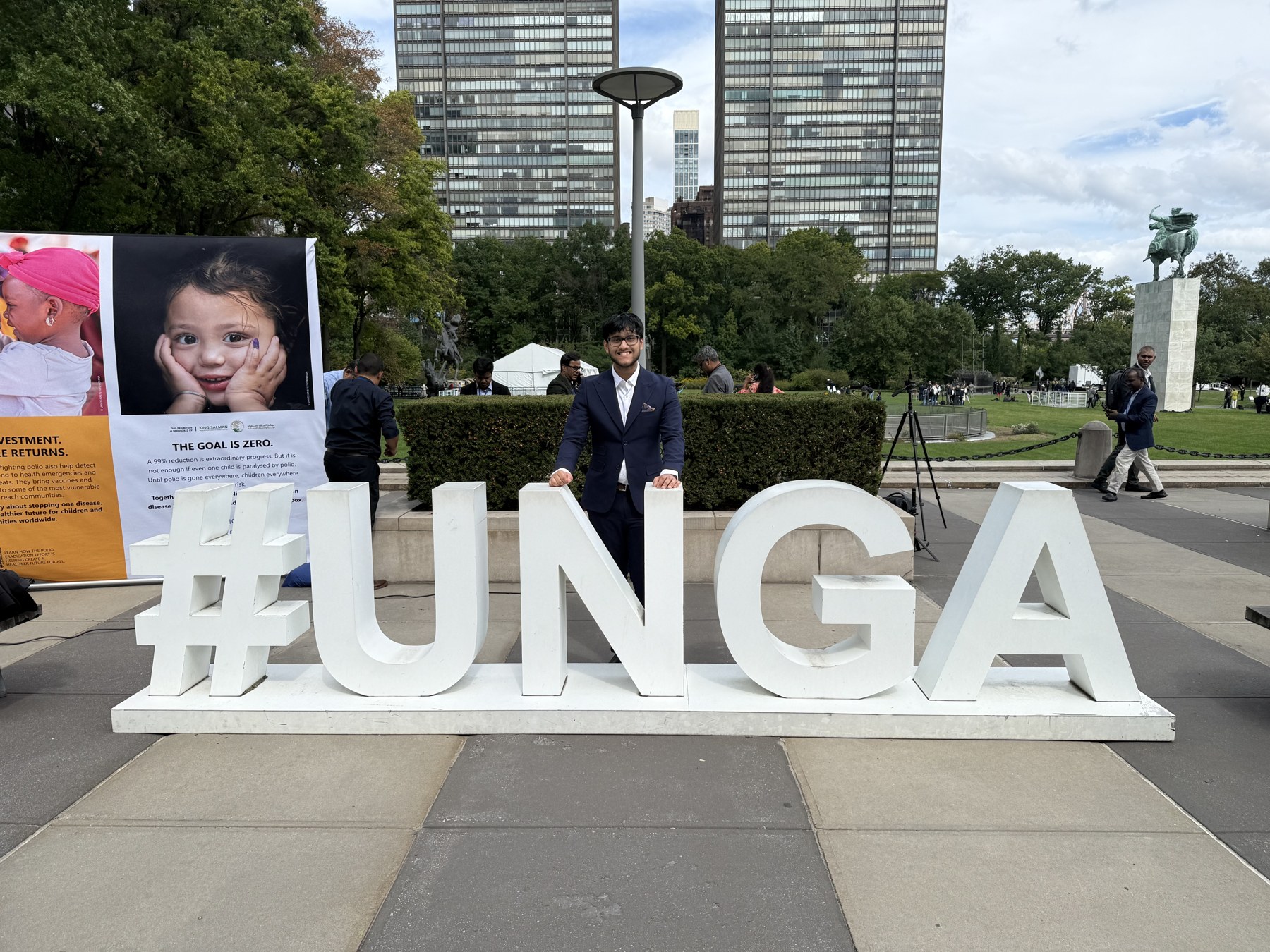 Rhythm Bazari beside the UNGA sign at United Nations Headquarters
